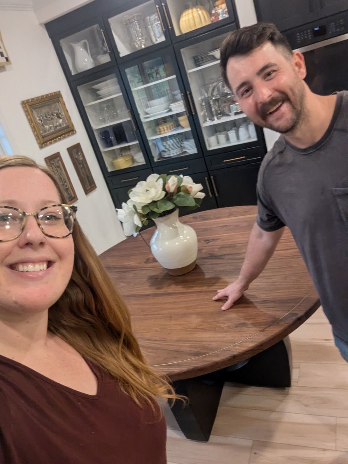 Julian and Kaitlyn Martin standing beside the completed walnut dining table on delivery day