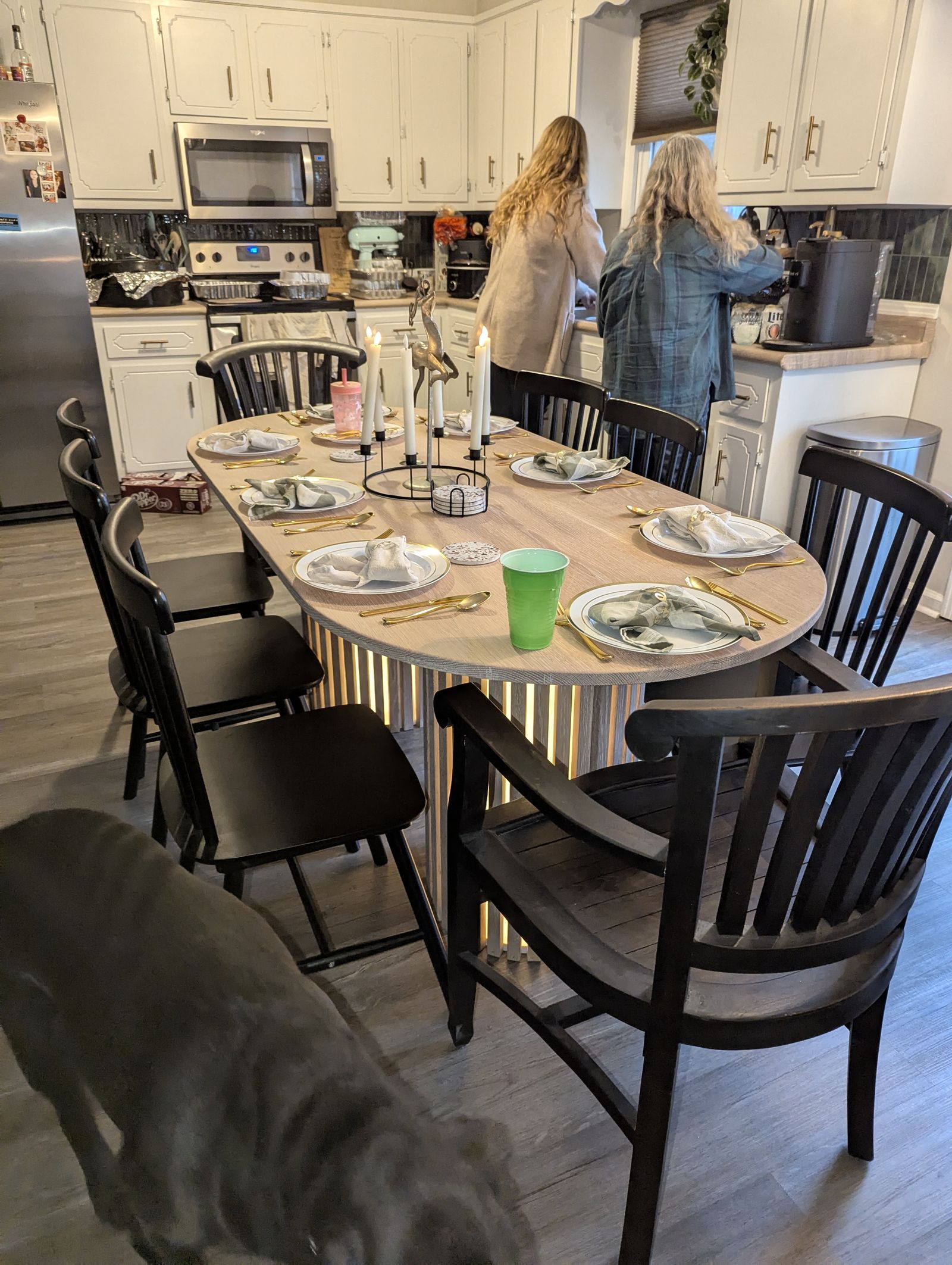 White oak oval table set for a family dinner with candles