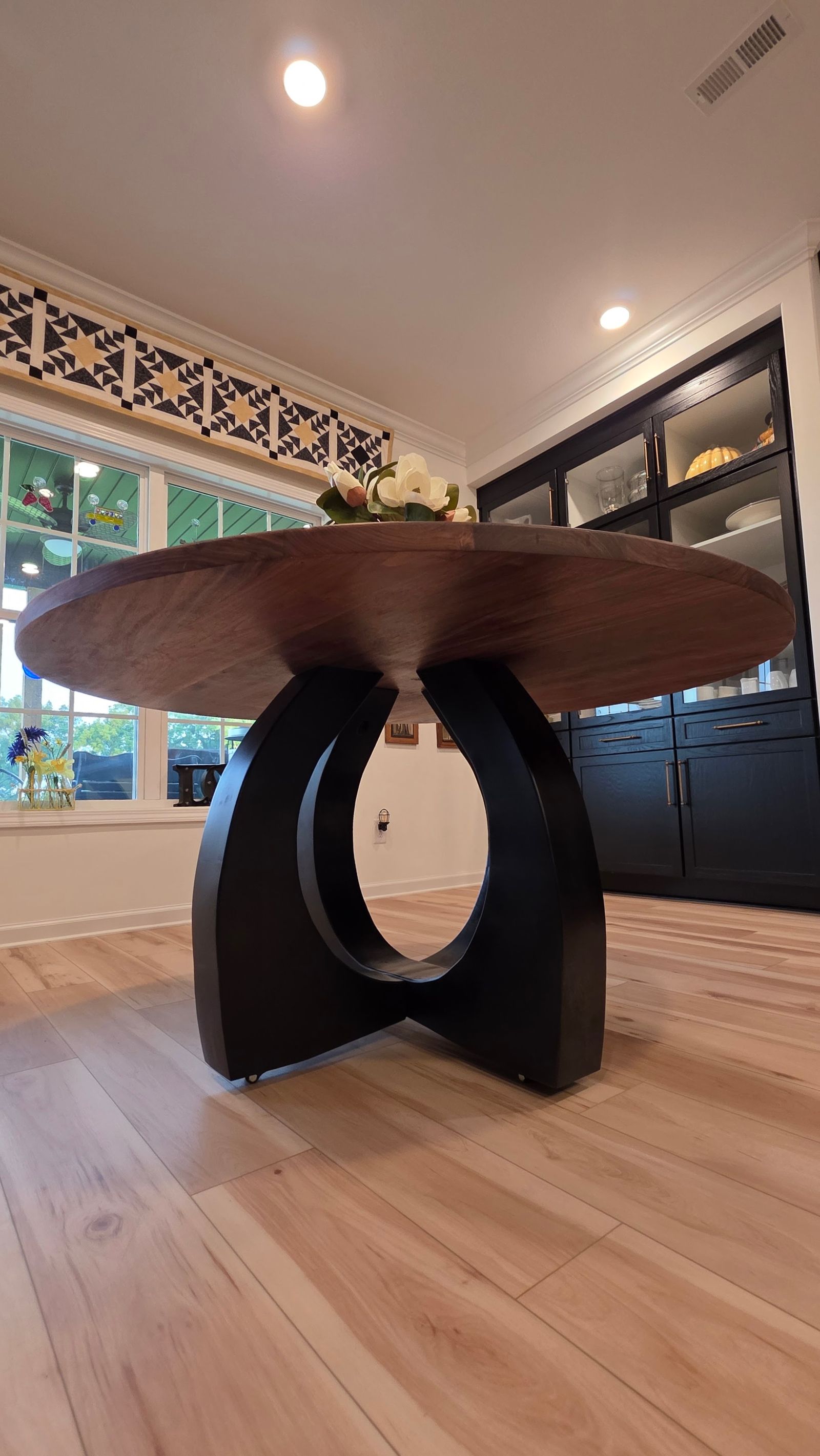Low angle of the black maple arch base under the walnut top